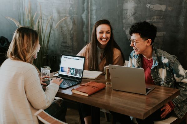 Students laughing at a table as they work